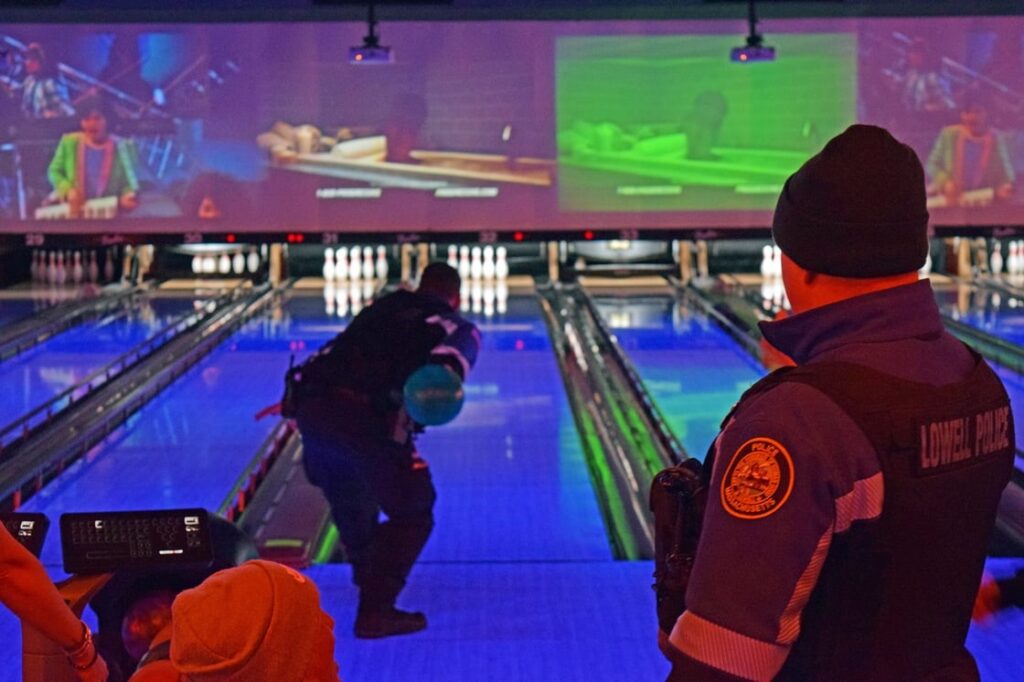 A police officer takes a shot at bowling at Bowlero in Lowell
